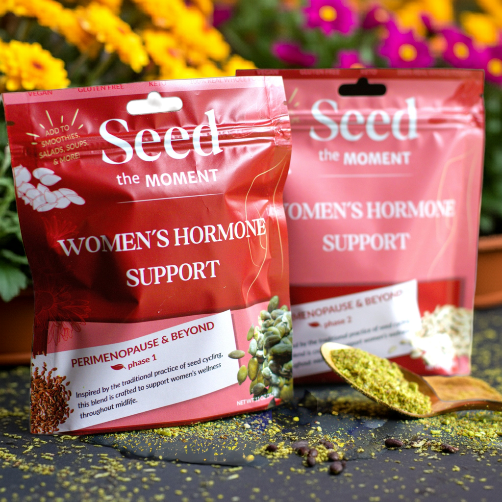 Two 'Seed the Moment' packages for women's hormone support with a spoonful of green powder on a dark surface.