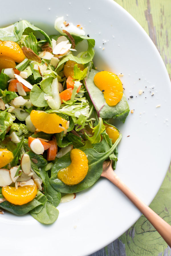 Salad with mandarin oranges and greens on a white plate