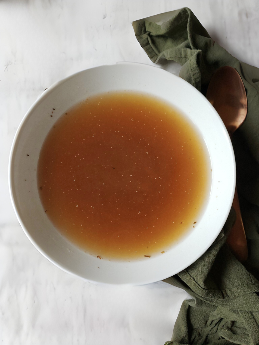 White bowl with brown liquid on a white background